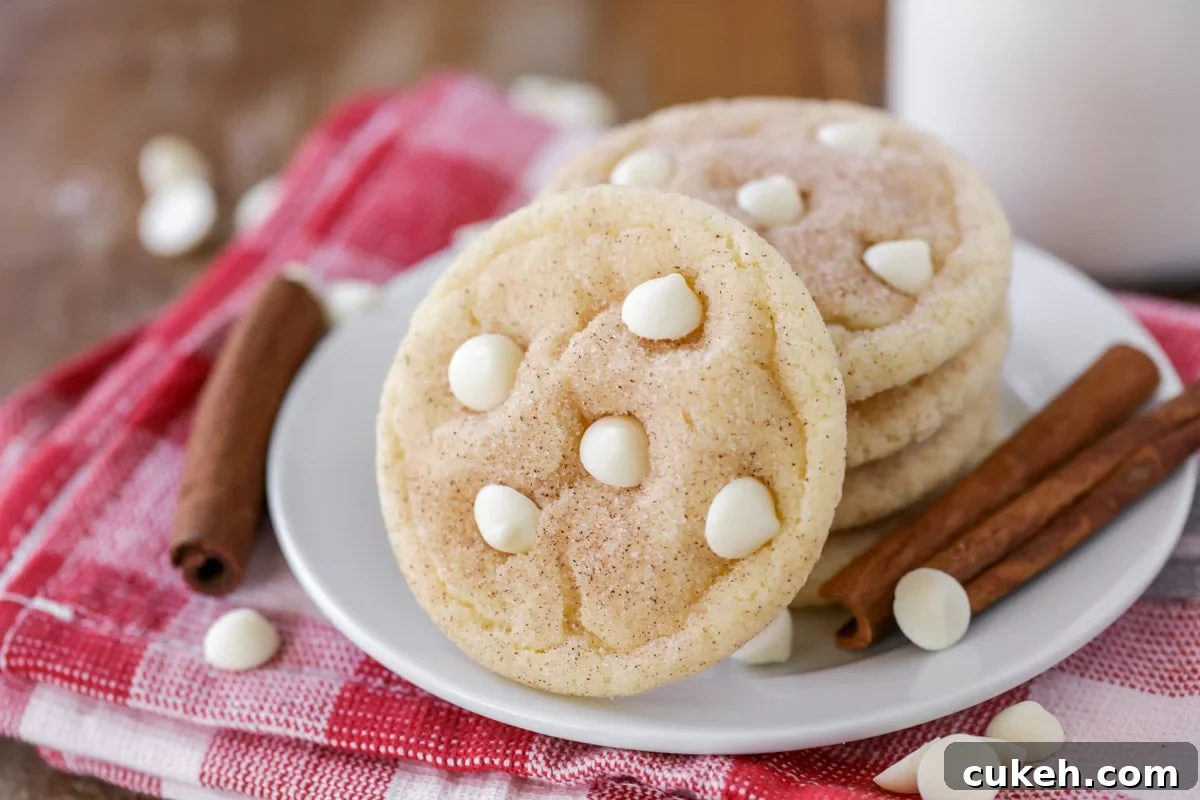 Snickerdoodle white chocolate chip cookies stacked on a white plate