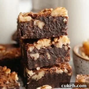 A stack of three fudgy walnut brownies.