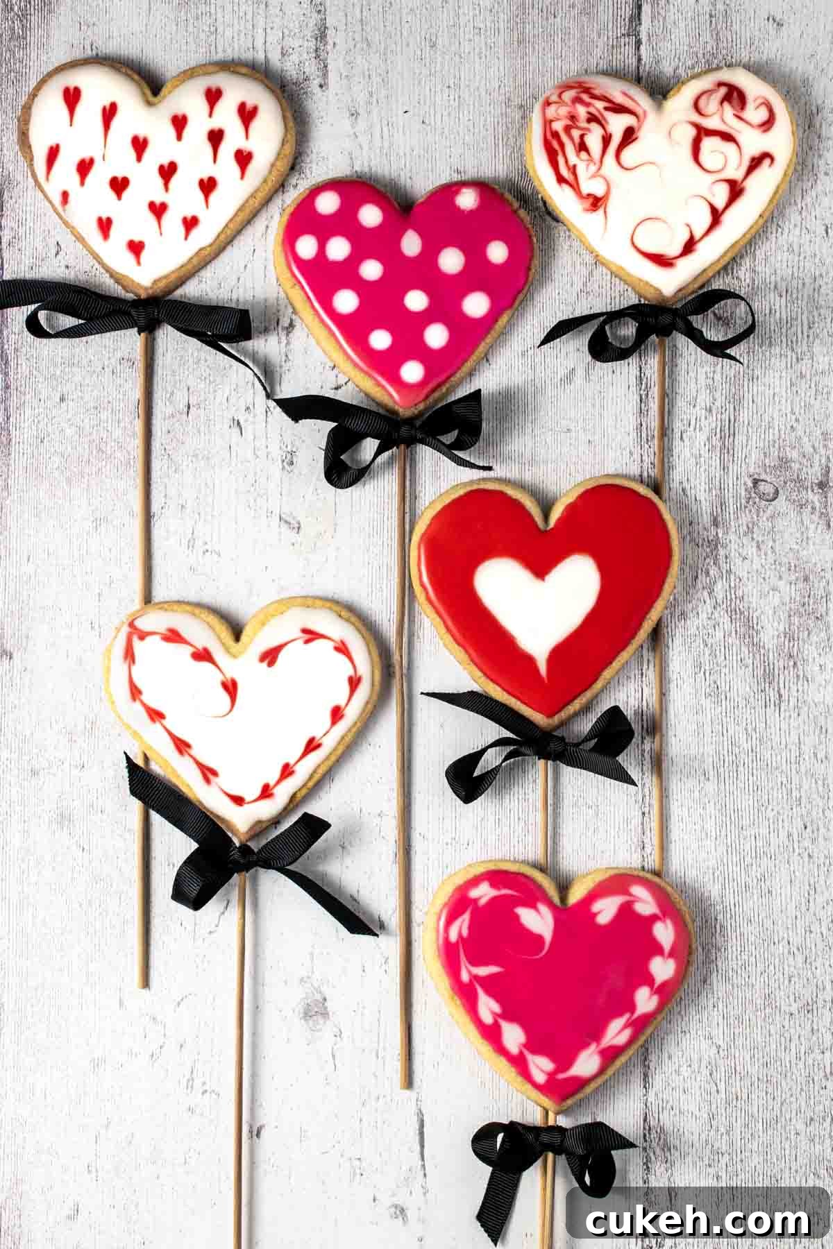 Six valentine's biscuits on sticks.