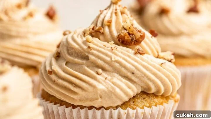 Four hummingbird cupcakes with pecans on top.