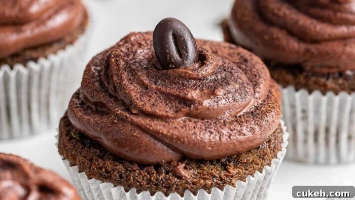 Up close photo of coffee cupcakes with chocolate frosting and espresso bean.