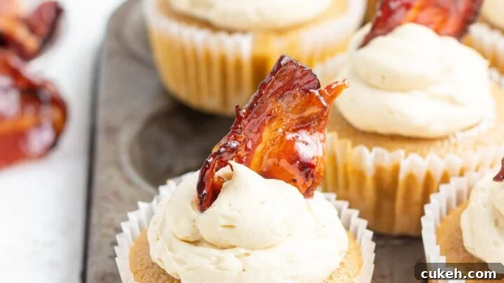 Close up of maple bacon cupcakes with bacon piece on top.