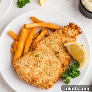Leftover fish reheated in air fryer and served with fries and a lemon slice.