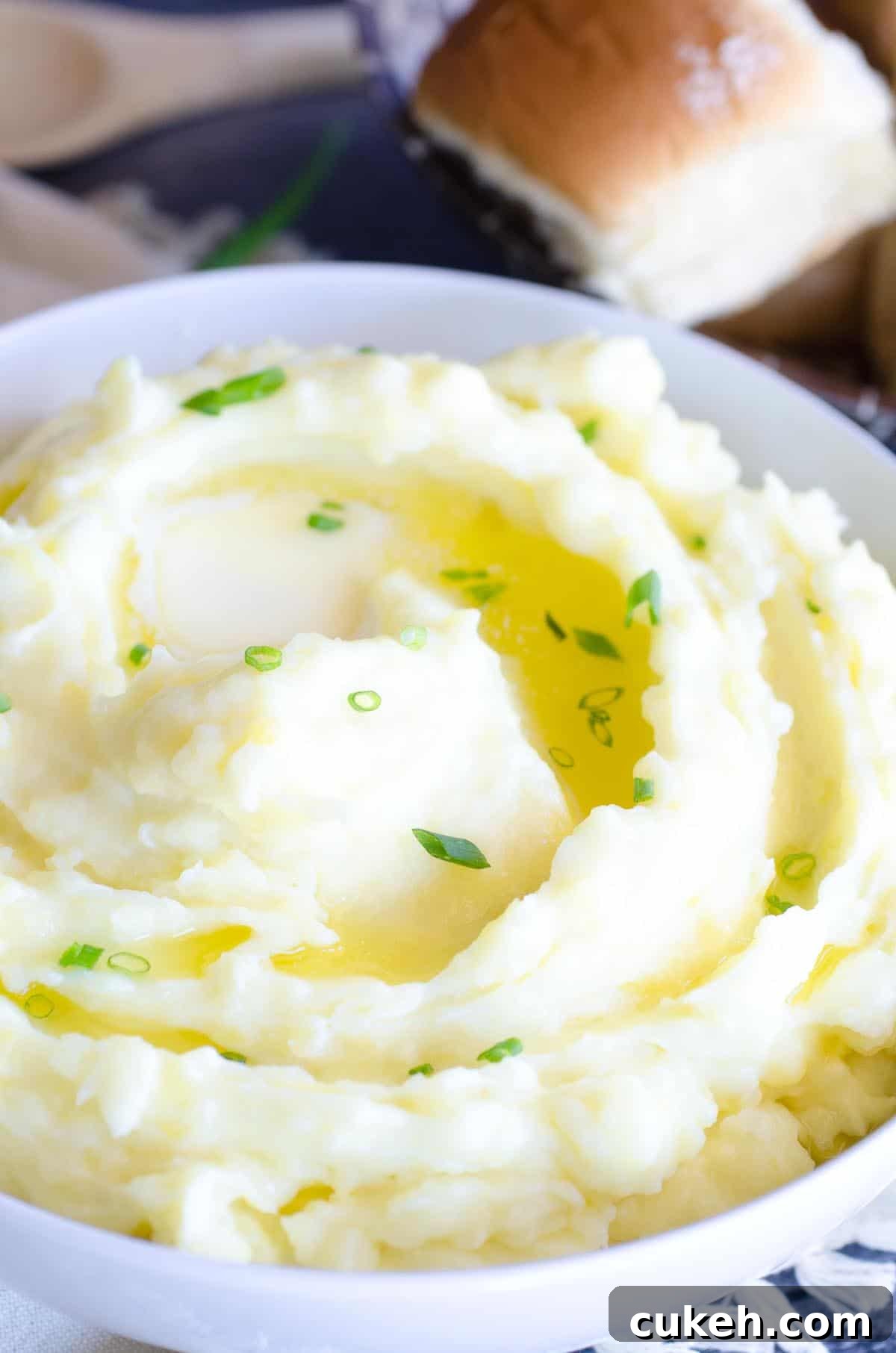 bowl of mashed potatoes with melted butter and chives on top