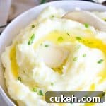 bowl of butter mashed potatoes with wooden spoon