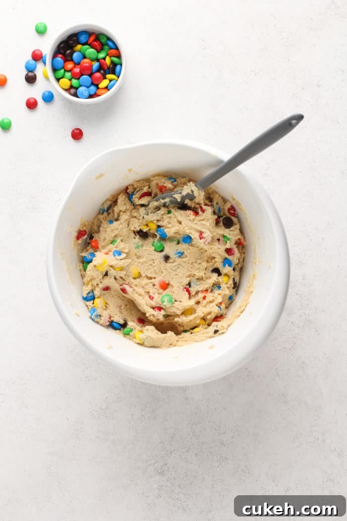 M&M cookie dough in a white mixing bowl.