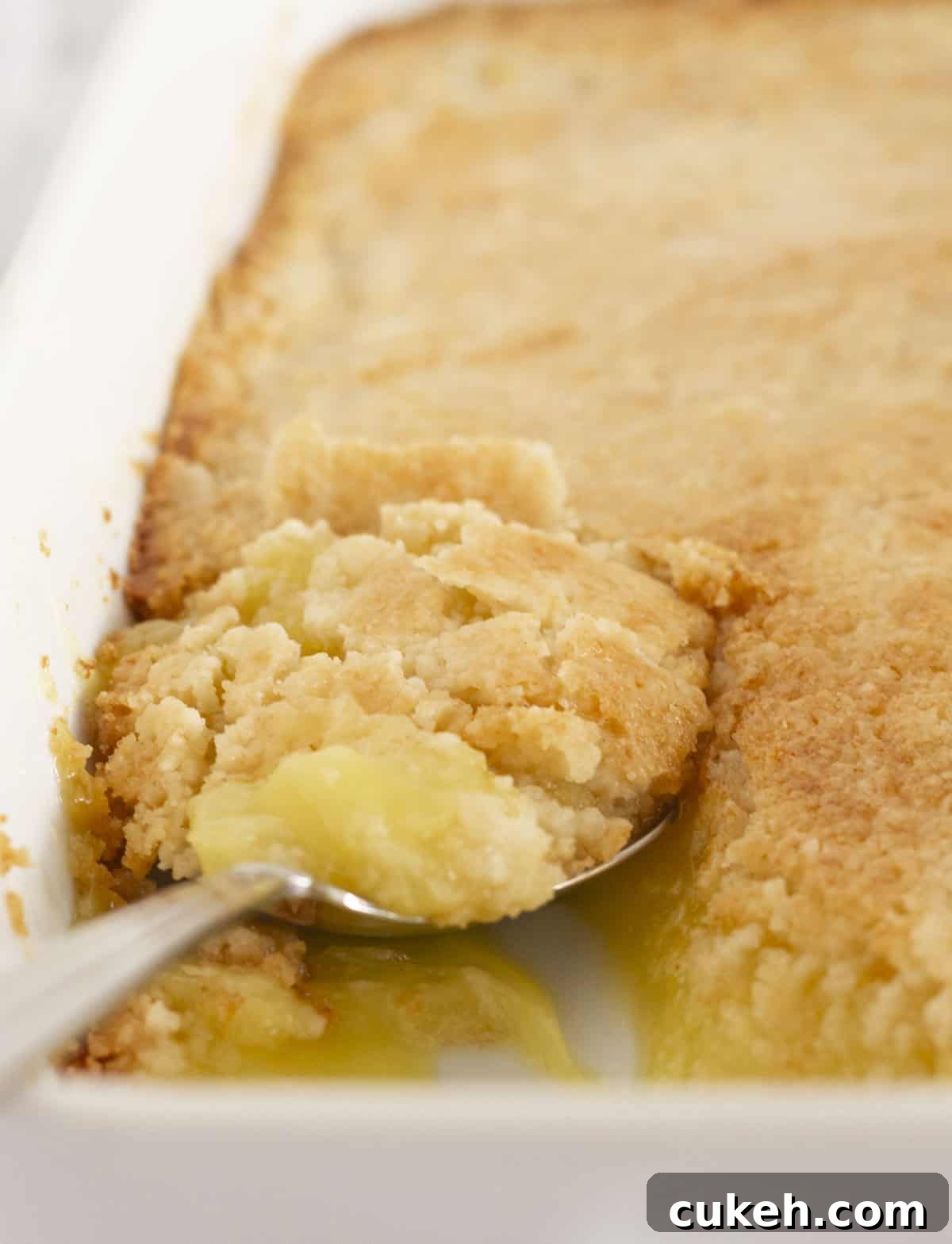 Getting a spoonful of lemon dump cake to serve.