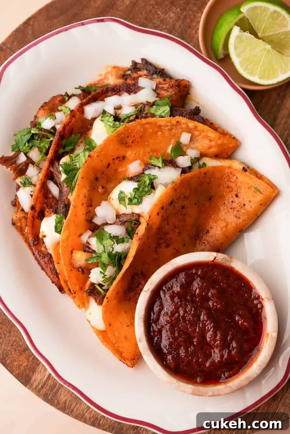 a plate of birria tacos with a side of consomé