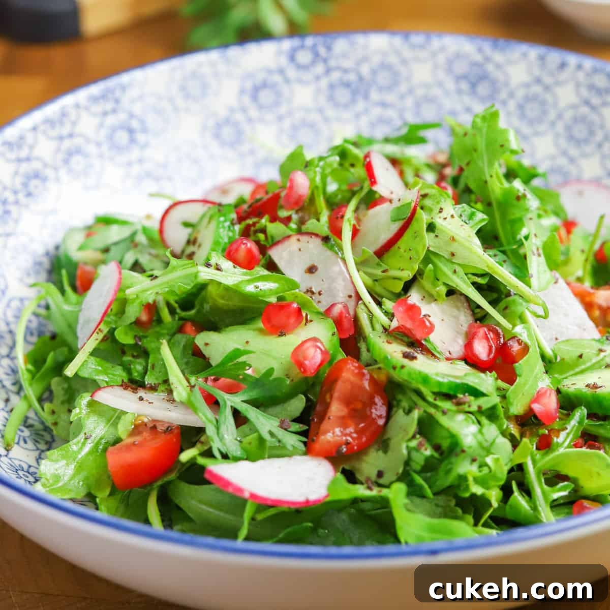 close-up photo of Middle Eastern Rocket Salad in a blue and white decorated bowl on a wooden table top.