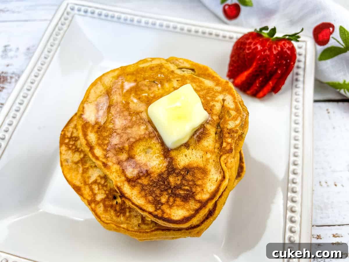 A stack of Sweet Potato Pancakes with a berry.