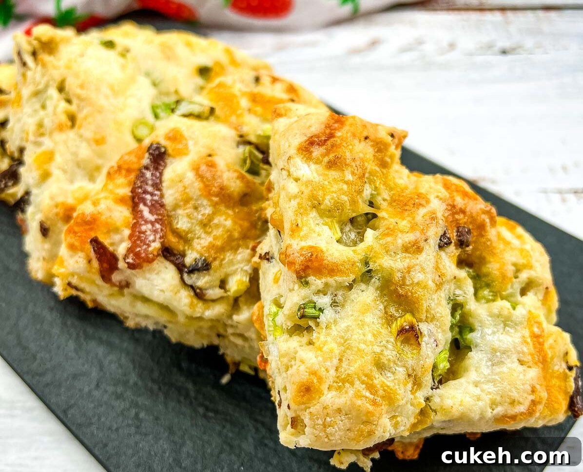 Bacon, Cheddar, Green Onion Scones on a black plate.