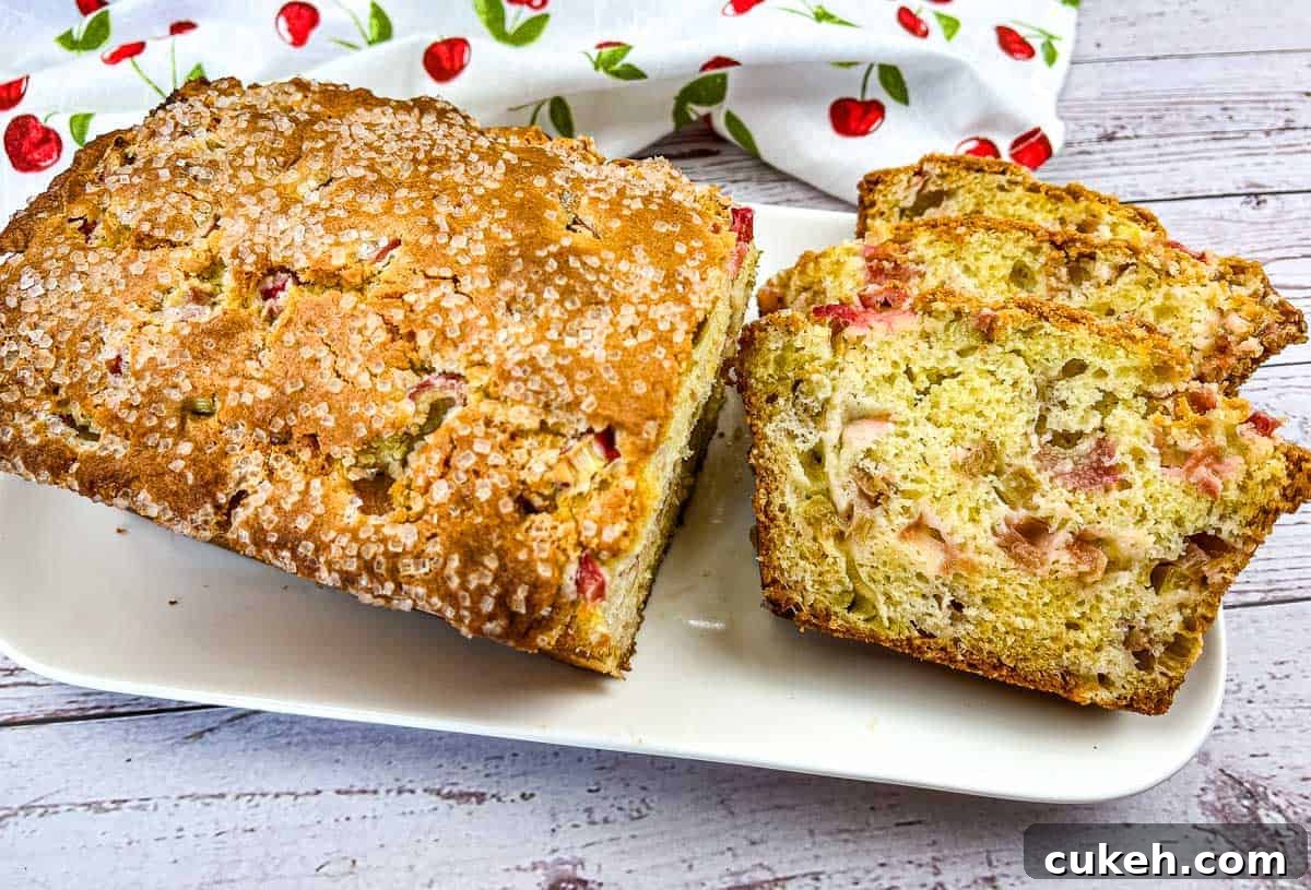 A loaf of Rhubarb Bread with a few slices on a white plate.