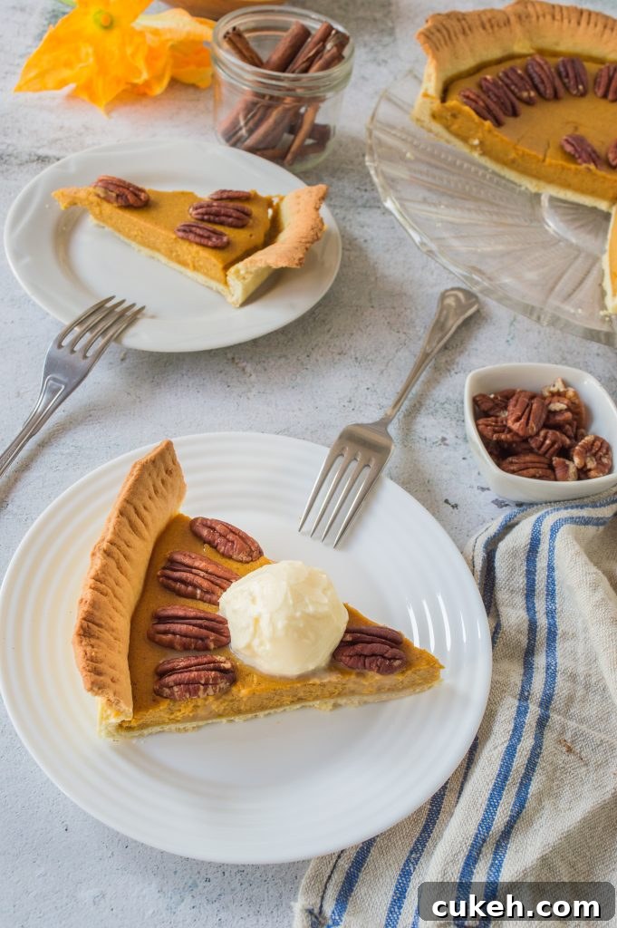 a slice of homemade pumpkin pie with pecans served on a small white plate with silver forks for eating