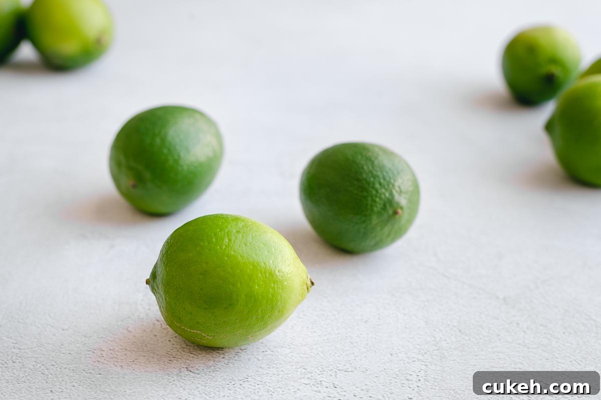 Fresh green limes on a grey concrete backdrop