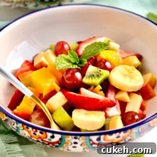 Spoon in a bowl of Italian fruit salad.