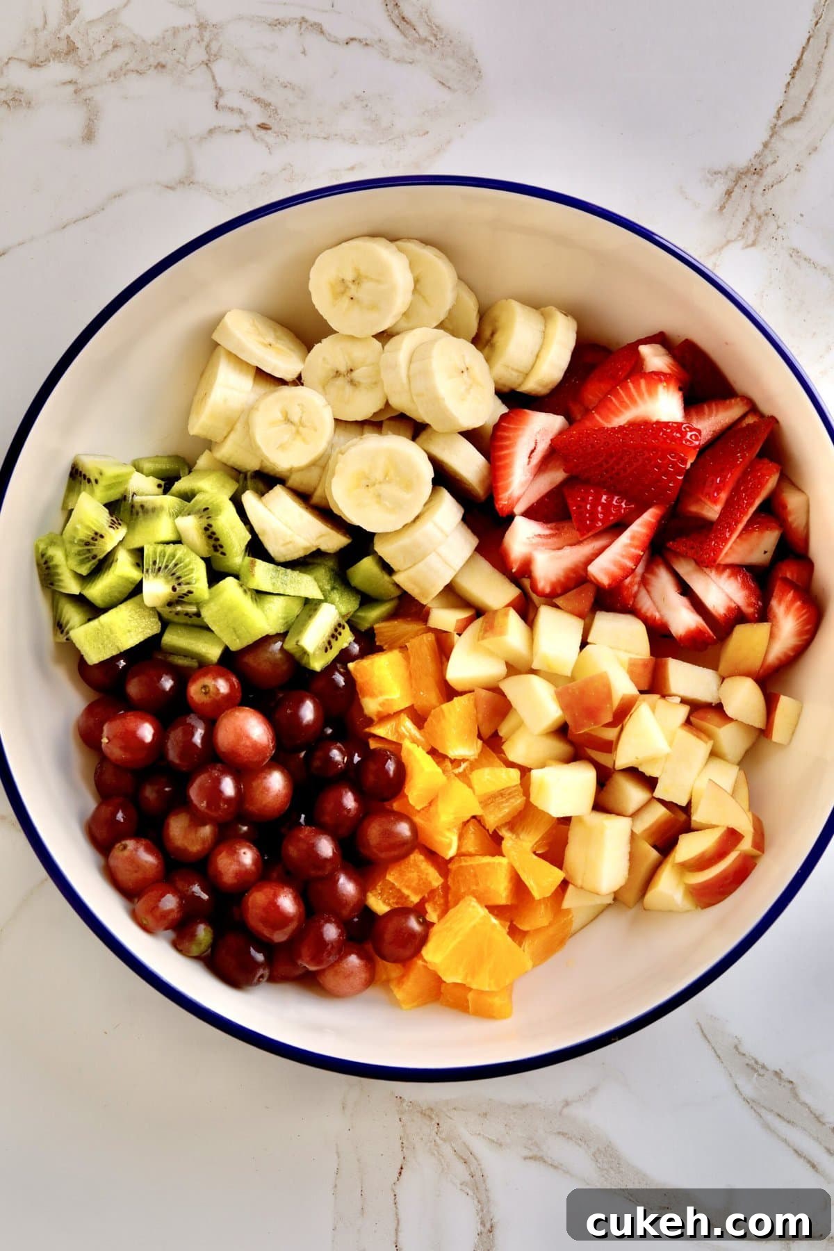 How to make Italian fruit salad recipe- chopping all the fruit and adding it to the bowl.