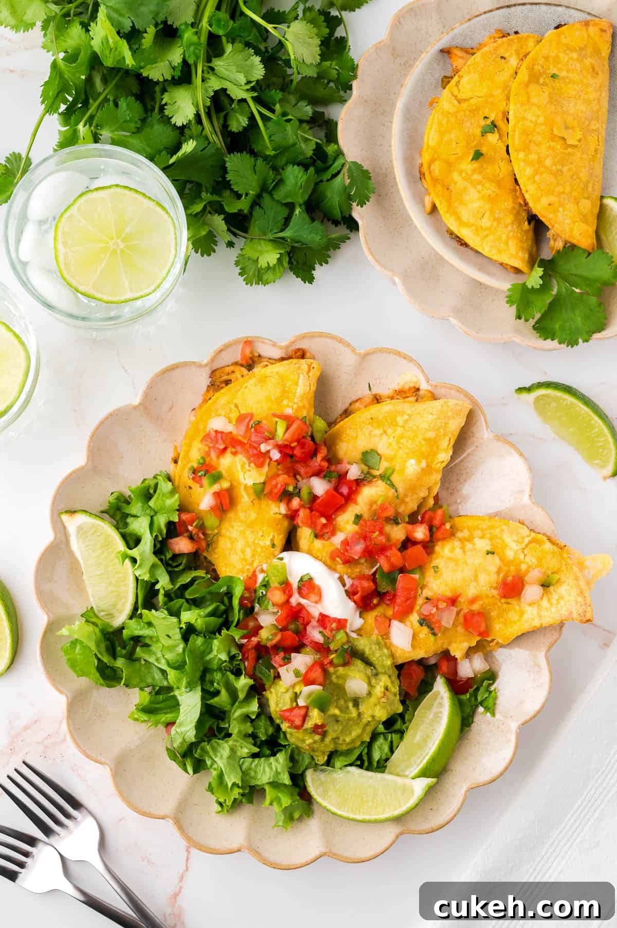 Three crispy chicken tacos served with lettuce, tomato and sour cream.