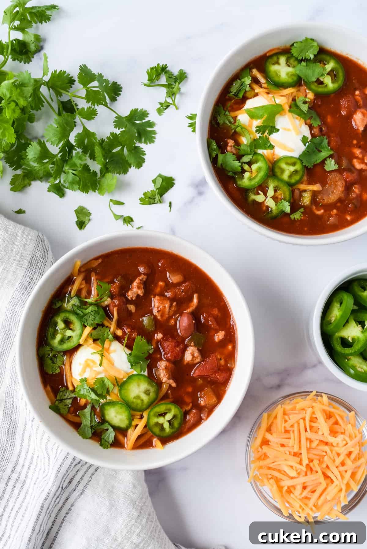 Slow Cooker Turkey and Bean Chili with cheddar cheese, cilantro, and jalapeños.