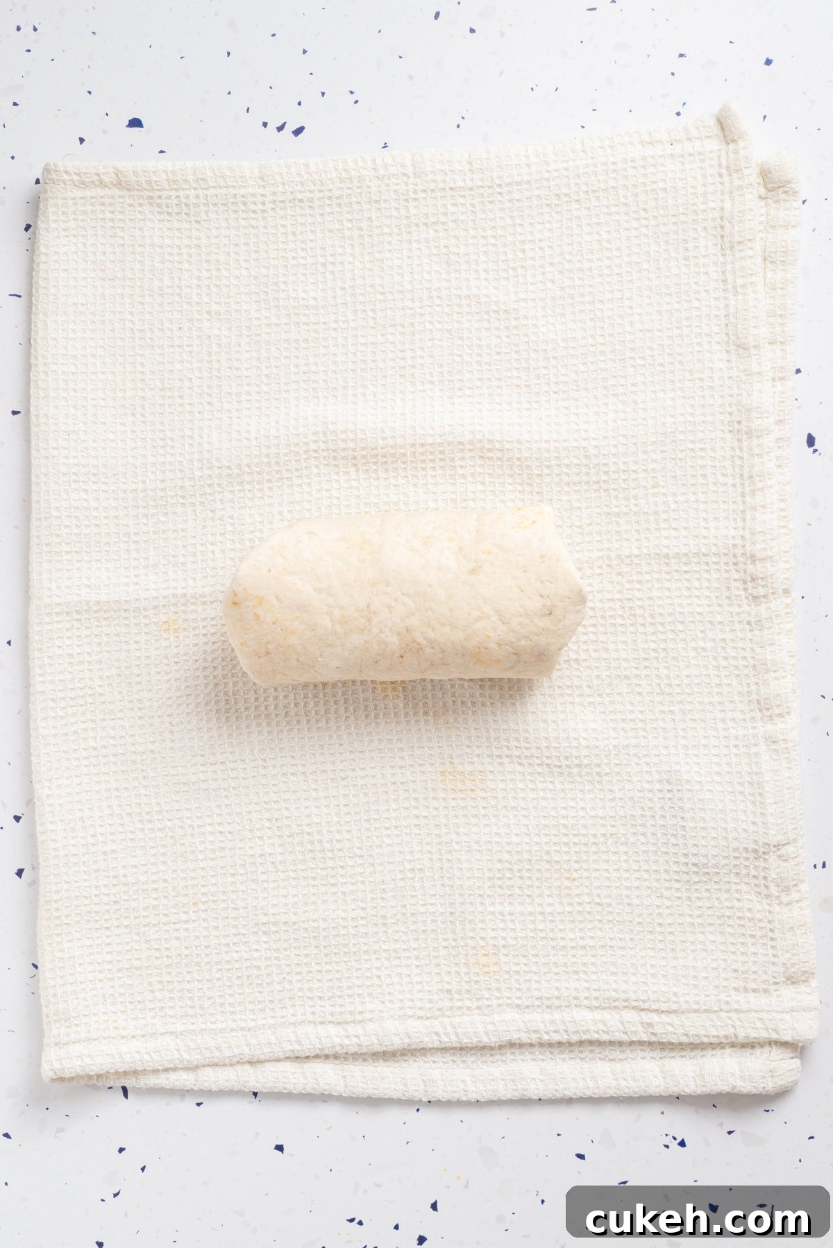 An overhead image of rolling the chickpea wrap.