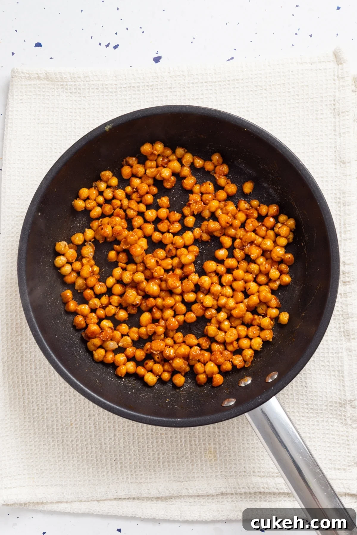An overhead image of cooked chickpeas in a pan.