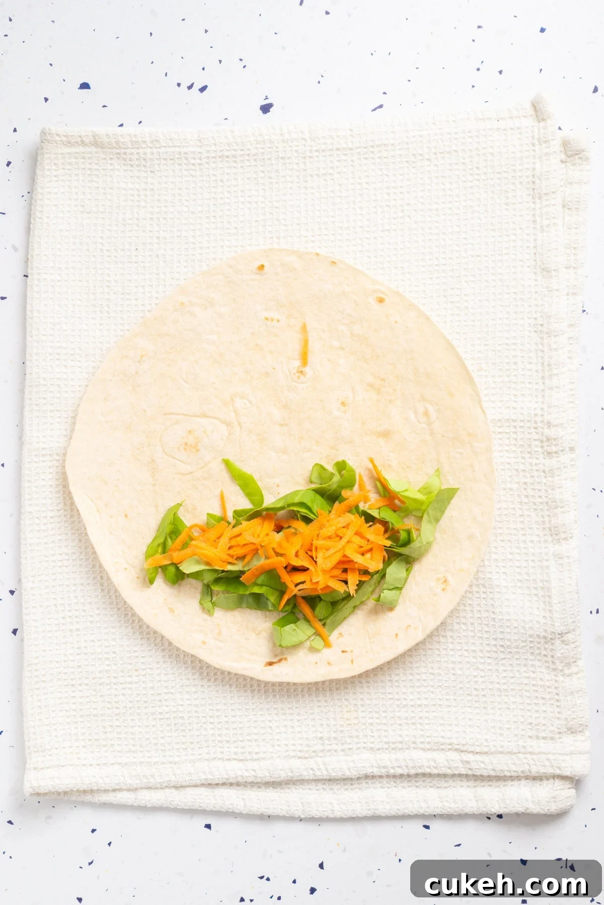 An overhead image of arranging veggies on tortillas.