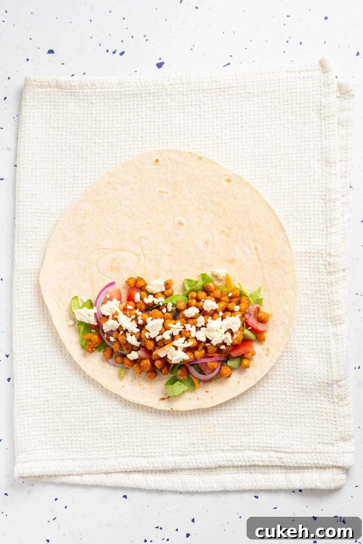 An overhead image of adding feta cheese to the wrap.