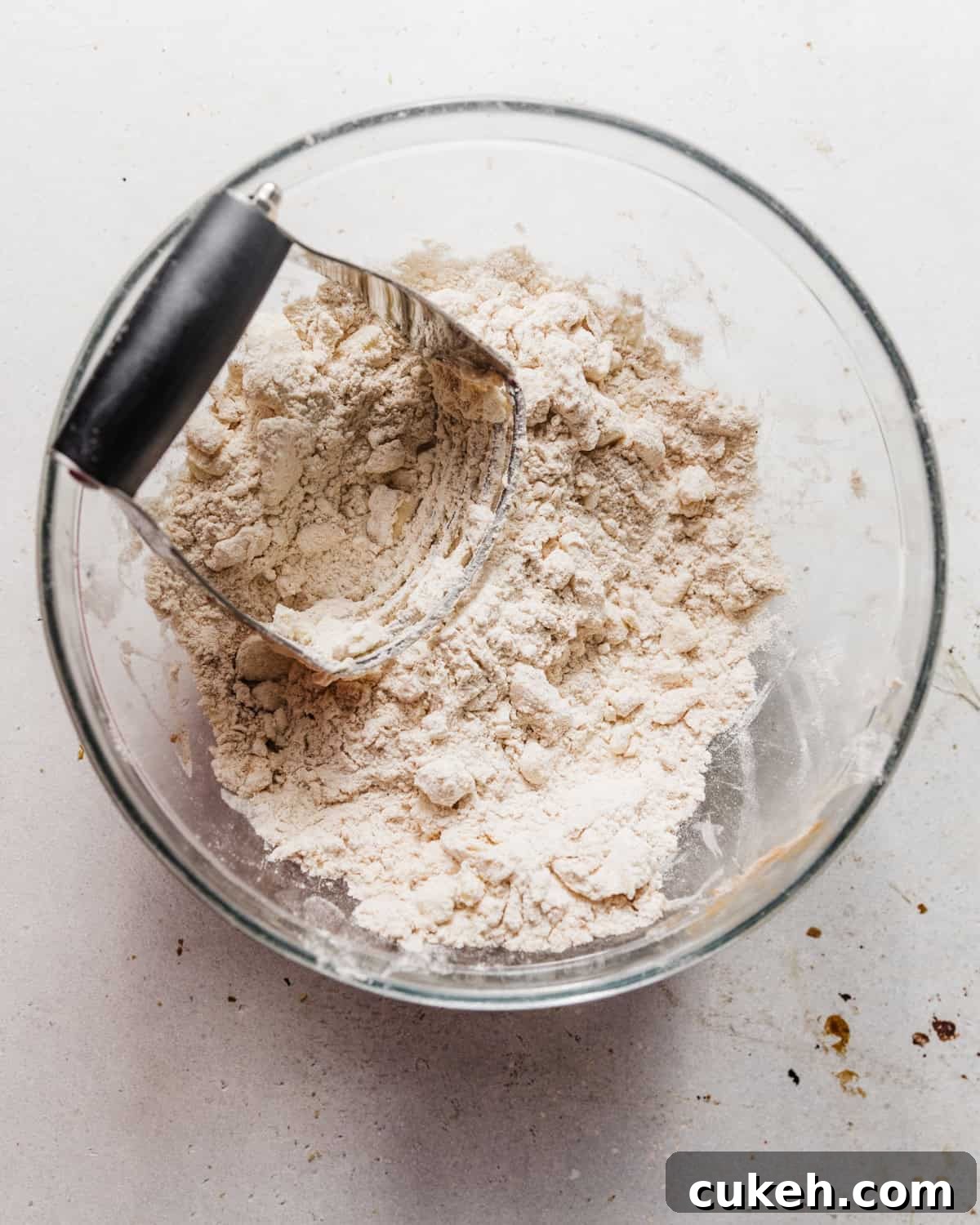 butter and flour mixed together in a bowl with a pastry cutter.