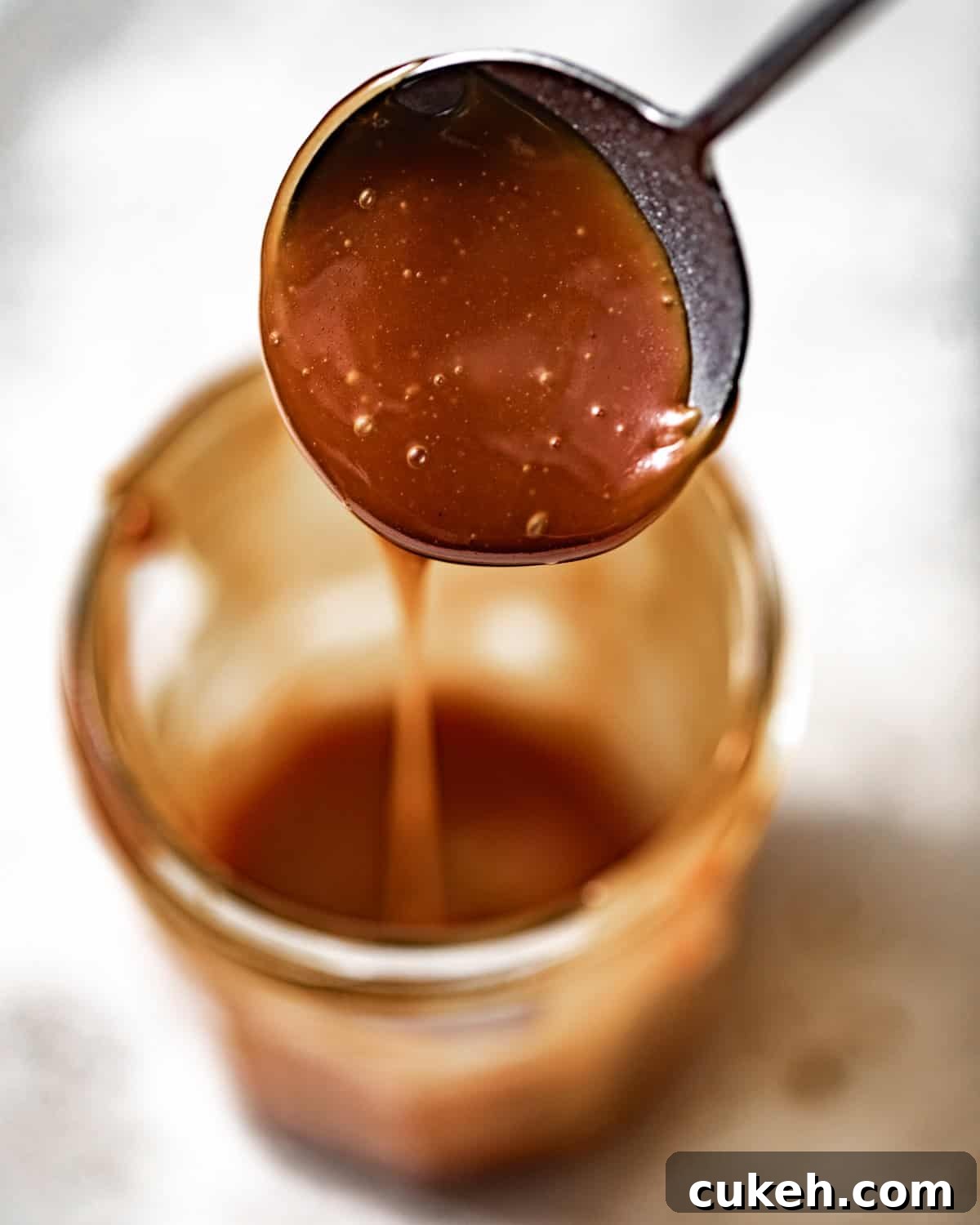 salted caramel sauce in a jar with a spoon.