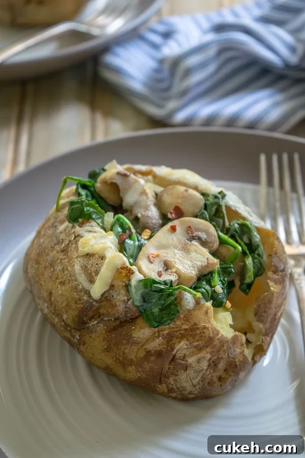 Spinach Mushroom Stuffed Baked Potatoes on a plate with a fork
