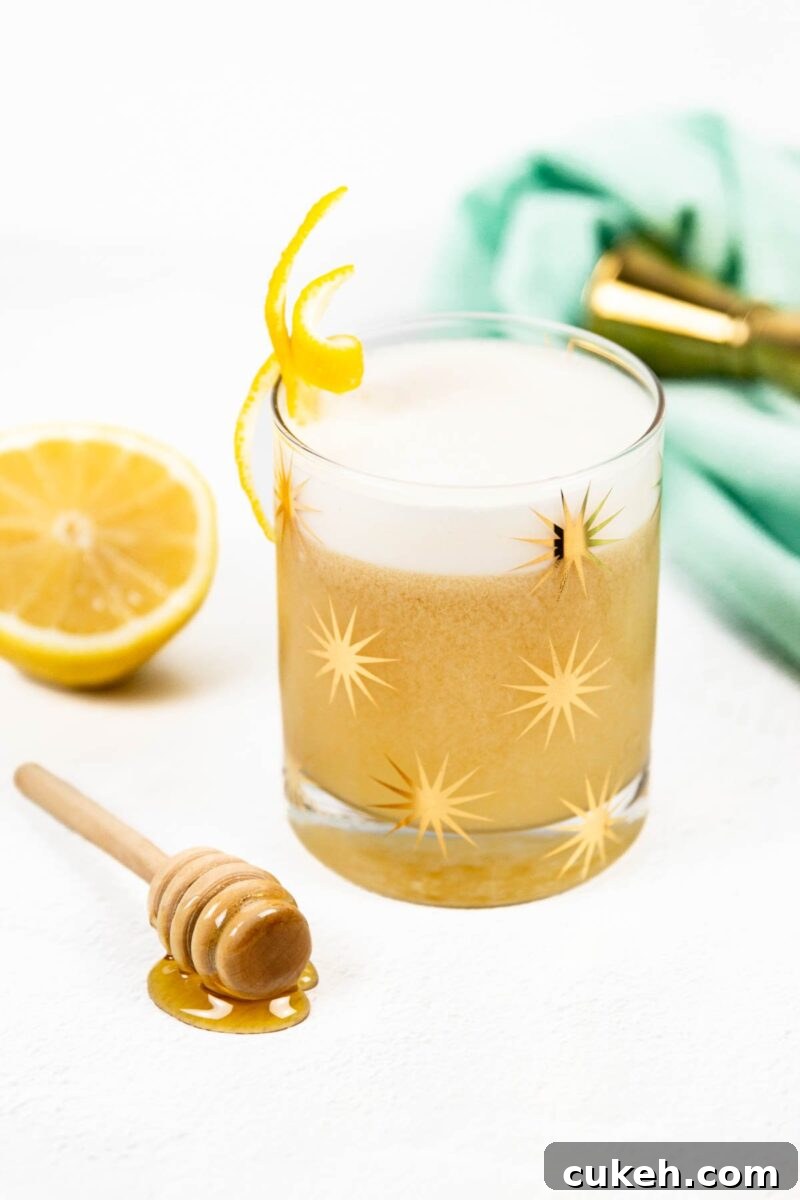 Honey lemon whiskey sour with a golden hue.