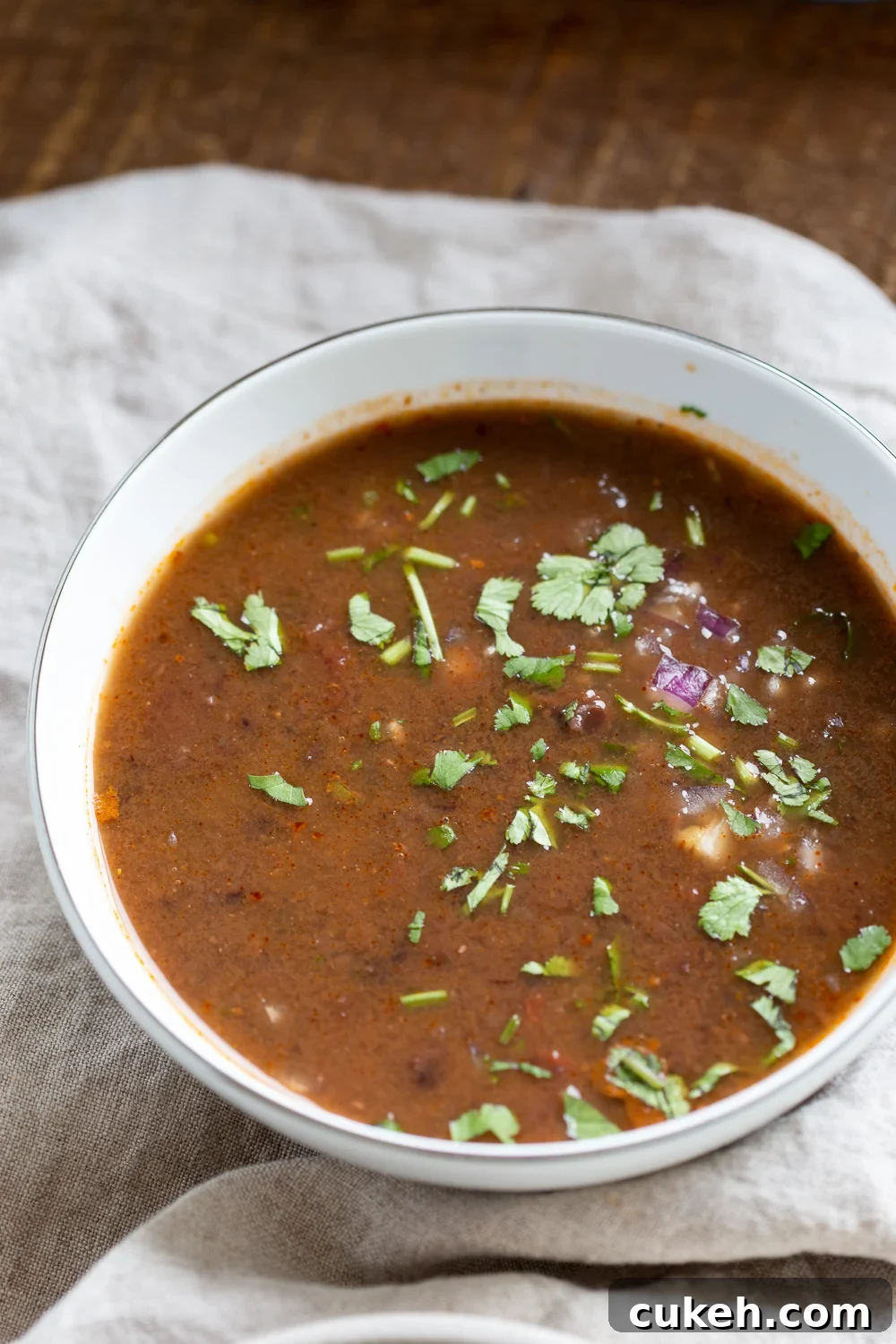 a bowl of vegan Instant Pot black bean soup sprinkled with chopped cilantro