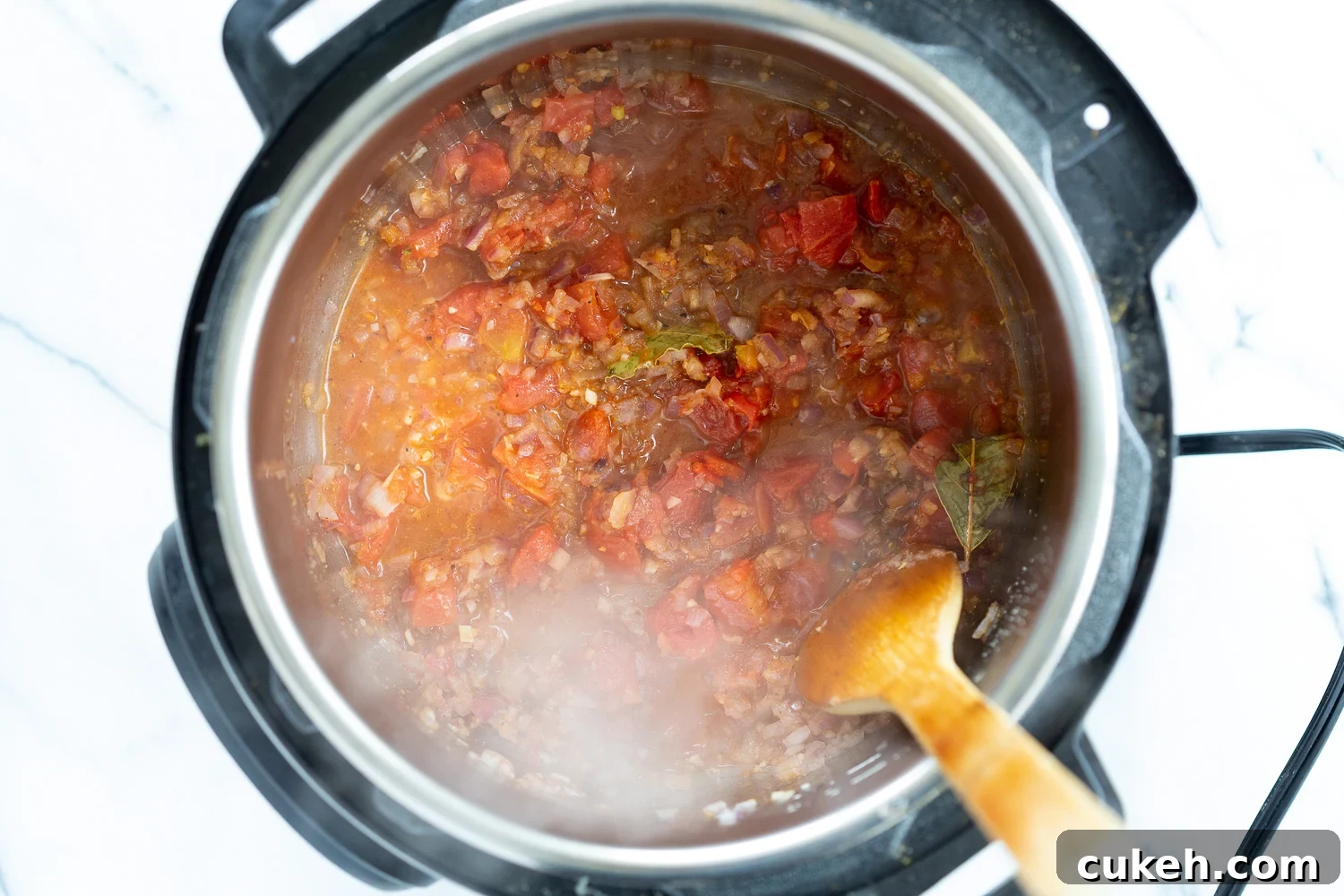 onion, garlic, spices and tomatoes simmering in an Instant Pot 