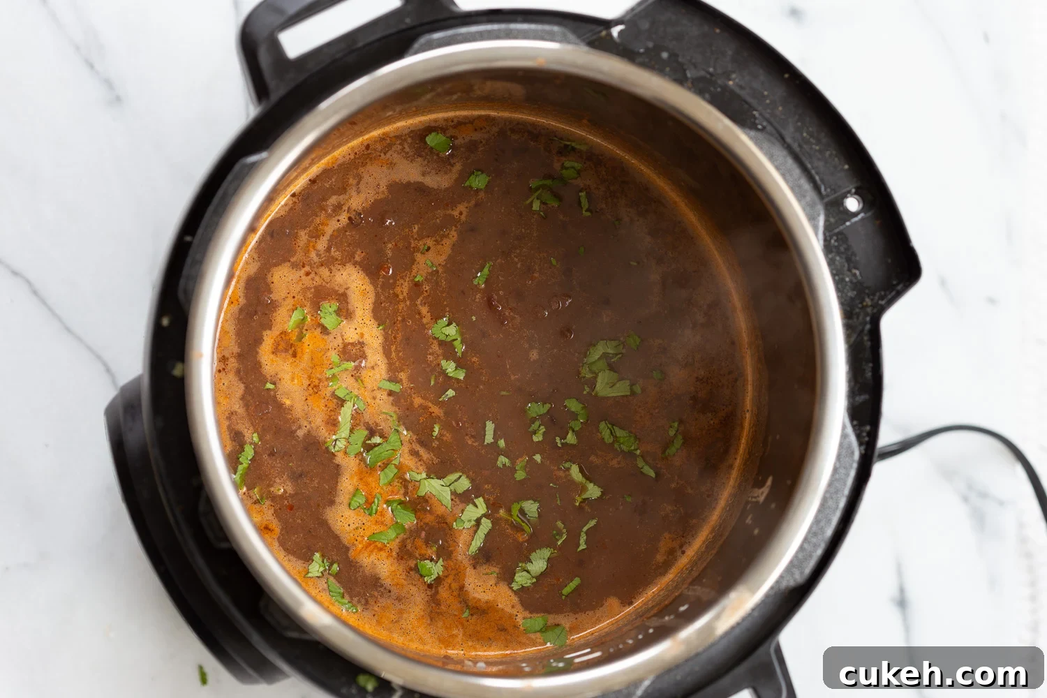 overhead shot of vegan black bean soup simmering in an Instant Pot 
