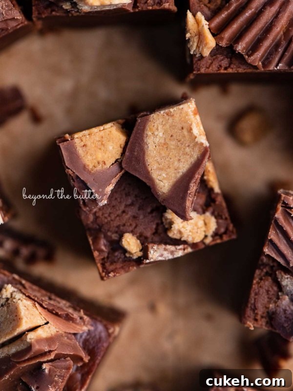 Sliced homemade chocolate peanut butter fudge on brown parchment paper.