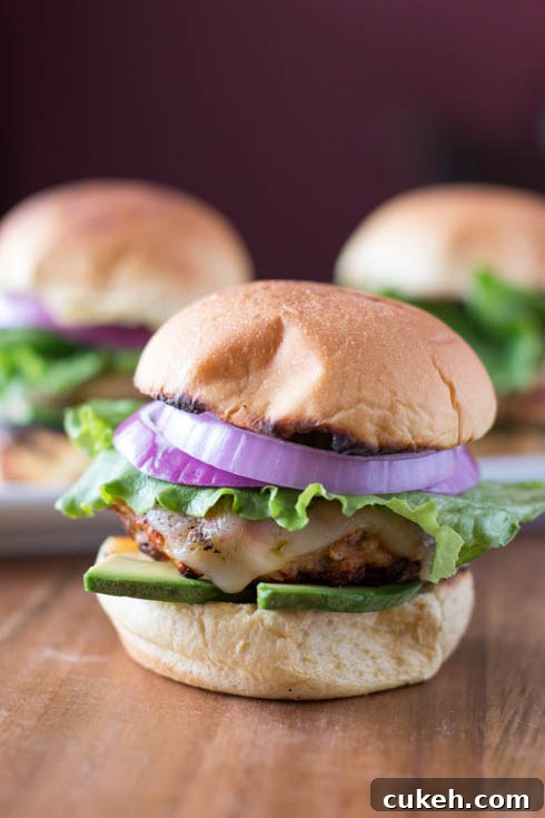 picture of grilled turkey burger sliders from the front with lettuce, red onion, and avocado.