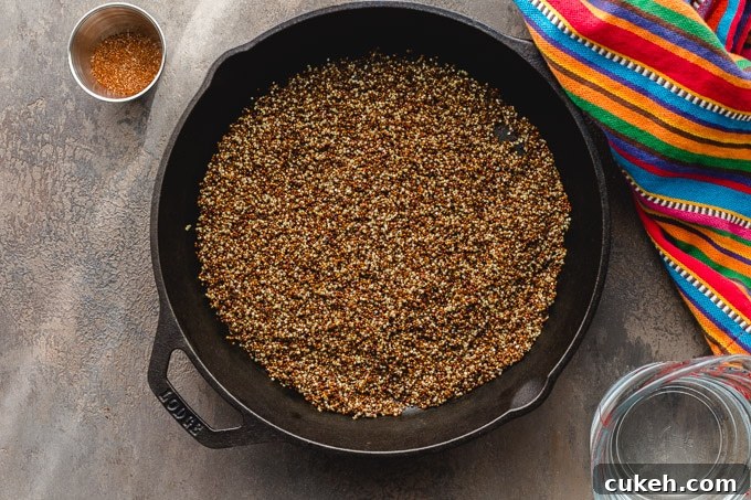 Overhead view of toasted quinoa in a cast iron pan.