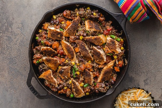 Quinoa casserole topped with salmon pieces in a cast iron pan.