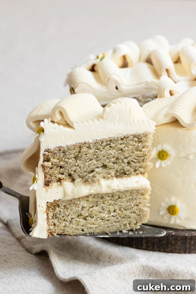 Slice of two layer banana cake being held on a pie server.