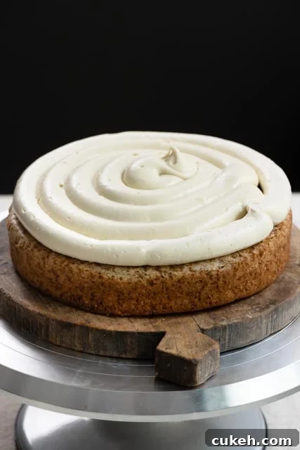 Single layer of banana cake on turntable, topped with frosting and banana cream filling.
