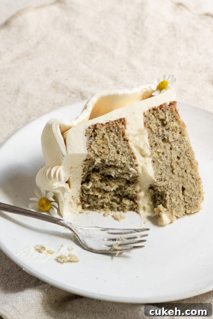 Slice of banana layer cake partially eaten on a plate with a fork.