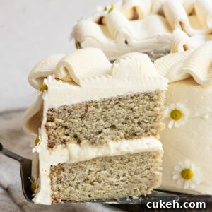 Slice of two layer banana cake being held on a pie server.