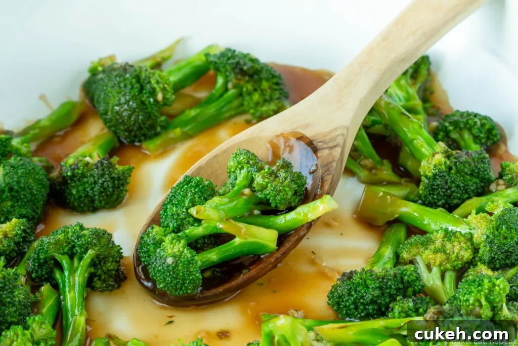 Asian broccoli stir fry in a skillet with a spoon.