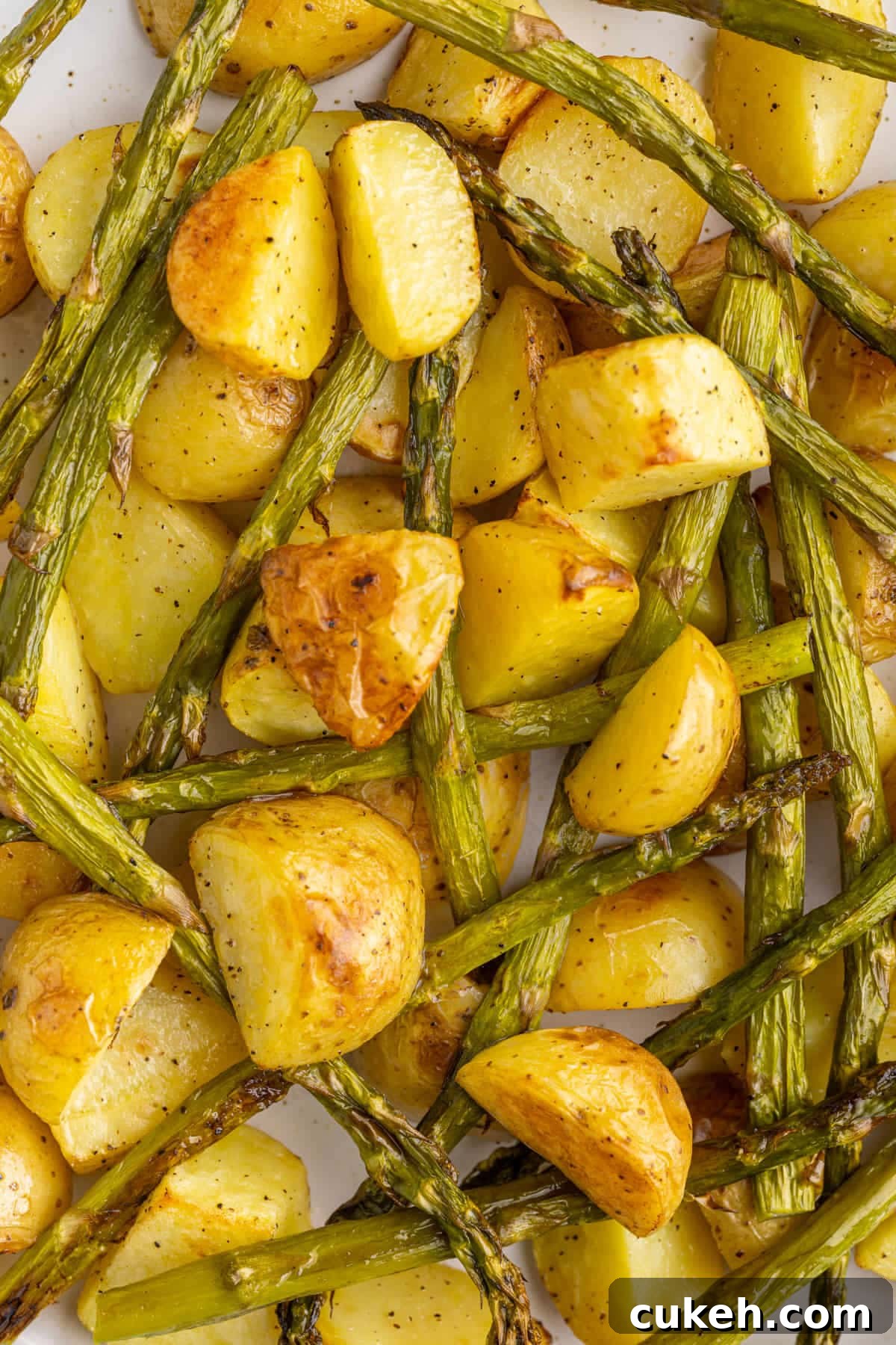 Close up of golden brown honey gold potatoes and crispy asparagus