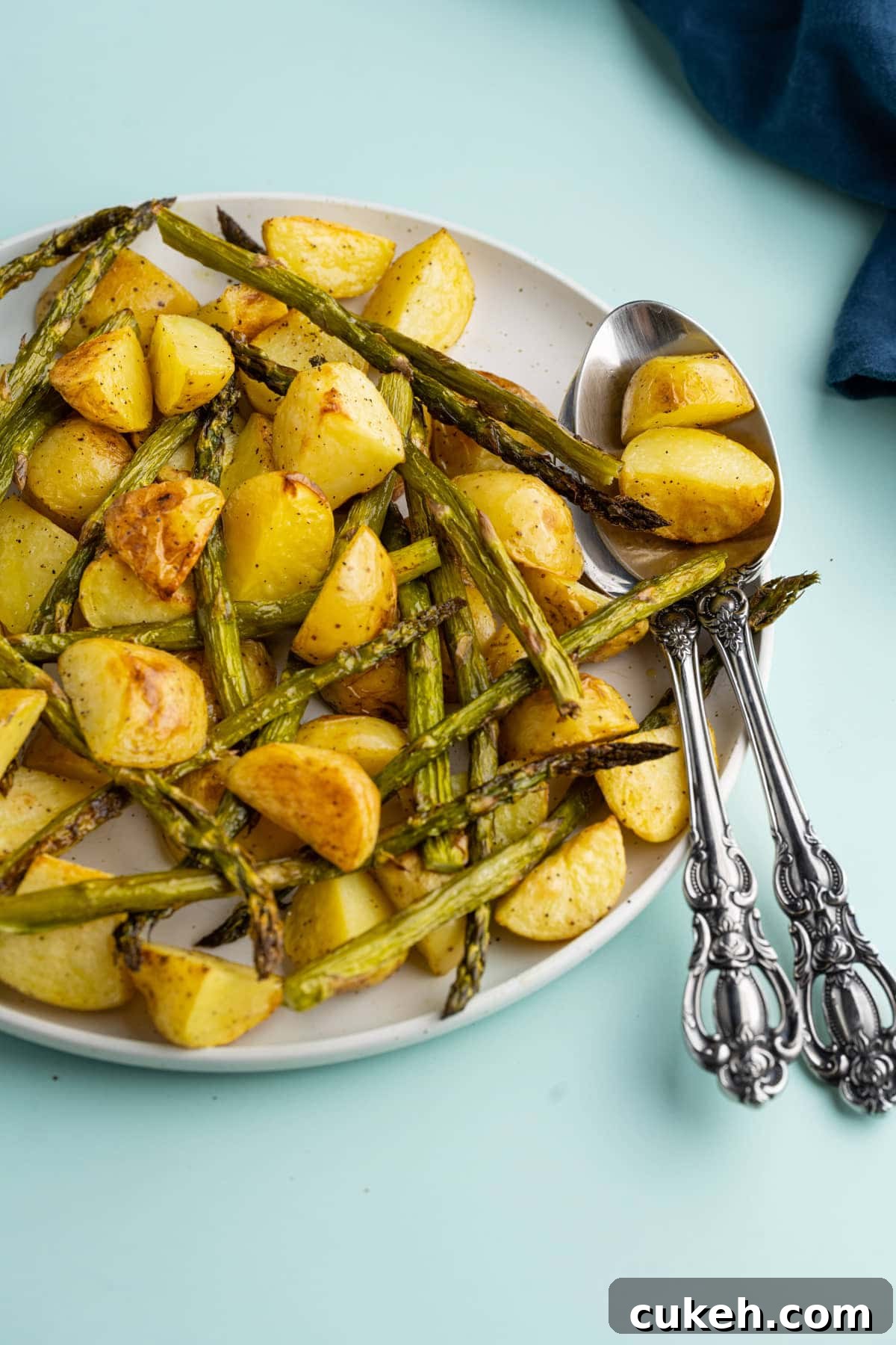 Serving platter with roasted potatoes and asparagus and serving spoons