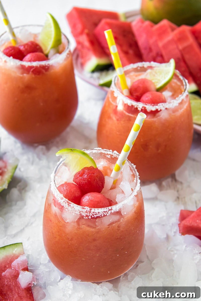 Watermelon Mango Margaritas watermelon mango margaritas with yellow straws and watermelon ball garish and lime garnish sitting on a bed of ice