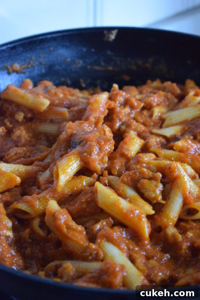 Penne pasta with sauce in a skillet.