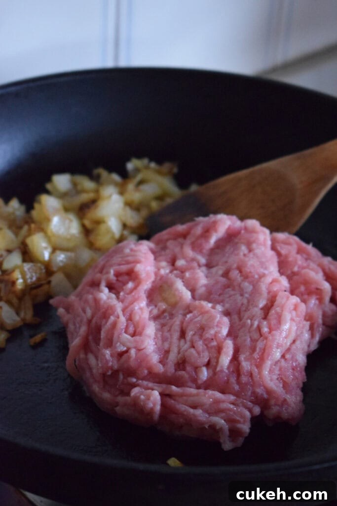 Ground turkey and onions in a skillet.