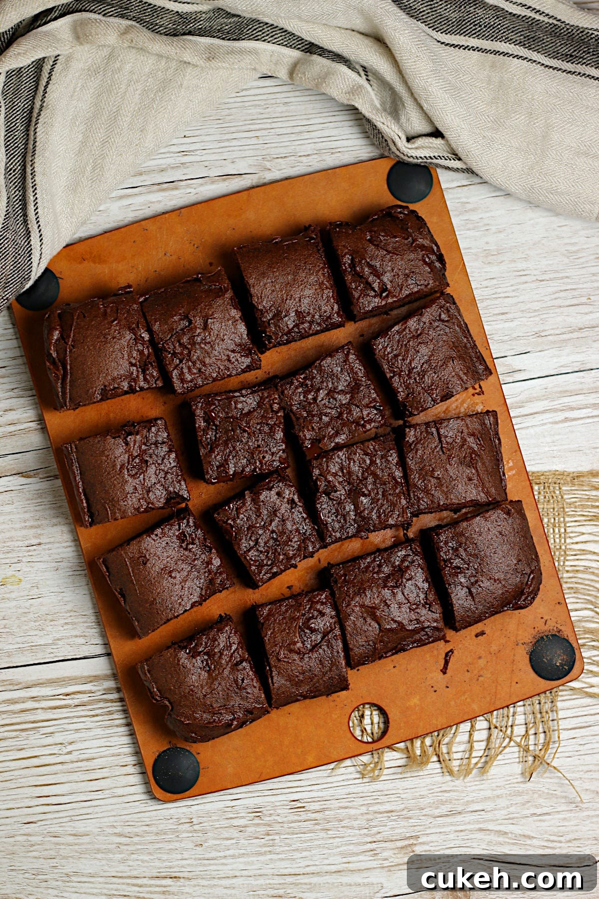 An overhead photo of a batch of Mocha Fudge Vegan Brownies cut into squares on a cutting board.