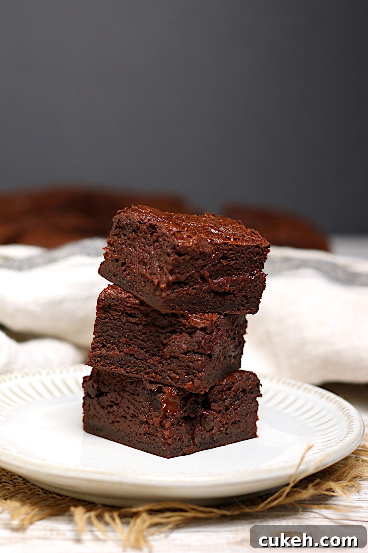 A stack of Mocha Fudge Vegan Brownies on a small white plate.