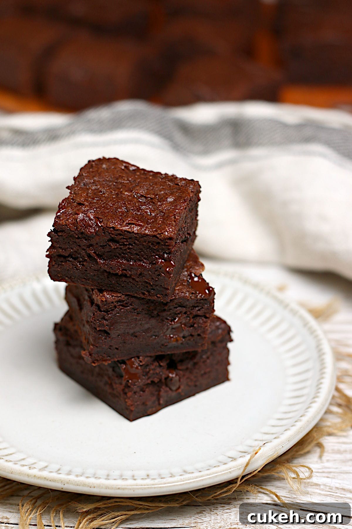 A stack of Mocha Fudge Vegan Brownies on a small white plate.
